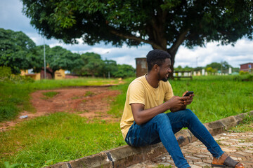 Fototapeta premium African American man using mobile phone in the park