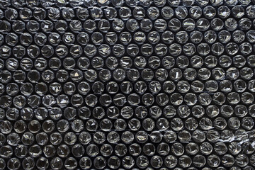 Plastic wrap air bubble packaging material on black background overlay texture