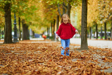 Adorable preschooler girl walking in Tuileries garden in Paris, on a fall day