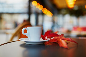 Cup of fresh espresso coffee on a table of traditional outdoor cafe in Paris, France