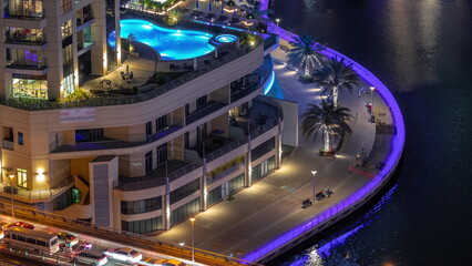 Dubai Marina waterfront and city promenade night timelapse from above.