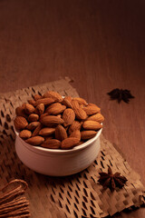 close up some almonds in bowl in dark background