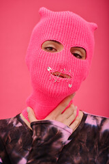 Portrait of young woman wearing pink balaclava with sewed mouth having no rights to speak - obrazy, fototapety, plakaty
