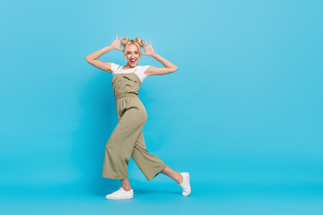 Fototapeta na wymiar Full length photo of sweet blond lady dance wear t-shirt overall footwear isolated on blue background