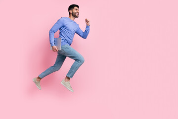 Fototapeta na wymiar Full length photo of sweet funny arabian man wear long sleeve shirt holding gadget jumping running isolated pink color background
