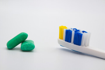 Chewing gum and a toothbrush on white background Dental care concept.