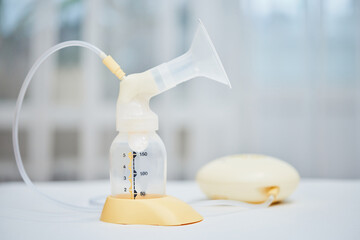 Breast pump with empty baby bottle on table