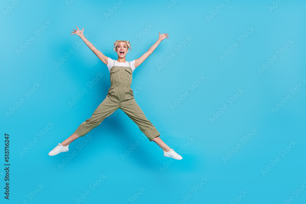 Sticker Full body photo of hooray young lady jump wear t-shirt overall sneakers isolated on blue background