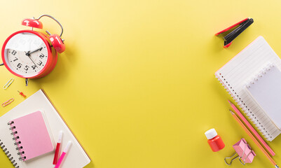 Education or back to school Concept. Top view of Colorful school supplies with books, color pencils, calculator, pen cutter clips and apple on pastel paper background.