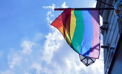 Pride rainbow lgbt gay flag being waved on sky background