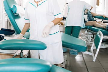 Obraz premium Nurse prepares chair for blood donors in medical laboratory. International Blood Donation Day.