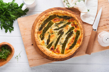 Quiche. Homemade asparagus pie or quiche with cheese and spinach on white wooden table background. Traditional French Quiche. Top view.