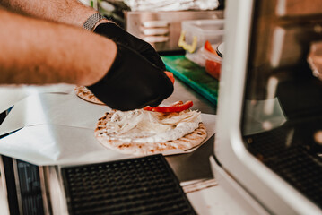 process of preparing traditional greek fast food - gyros. chef hand cooking food on kitchen