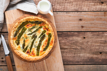 Quiche. Homemade asparagus pie or quiche with cheese and spinach on old wooden table background. Asparagus and cheese tart. French Quiche. Top view.