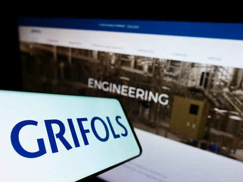 Stuttgart, Germany - 01-30-2022: Cellphone with logo of Spanish pharmaceutical company Grifols S.A. on screen in front of business website. Focus on center-left of phone display.