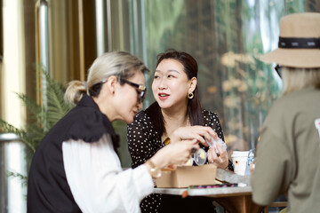 Asian women sitting and chatting  outdoors at coffee shop