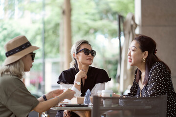 Asian women sitting and chatting  outdoors at coffee shop