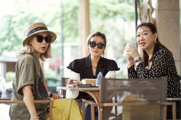 Asian women sitting and chatting  outdoors at coffee shop
