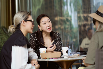 Asian women sitting and chatting  outdoors at coffee shop