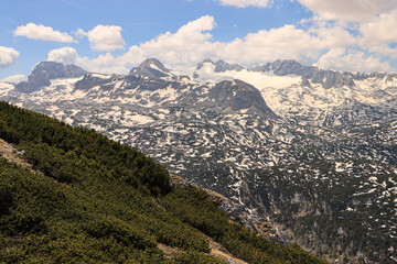 Wildromantische Alpenlandschaft; Blick zum Dachsteinmassiv vom Krippenstein im Mai 2022