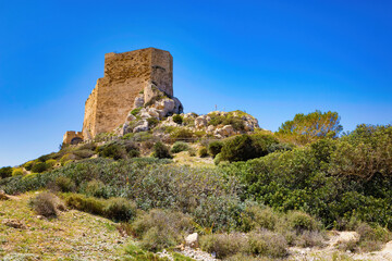 Octagonal tower of the castle of Cabrera, located at the entrance to the port overlooking the bay and the island of La Gomera. Balearic Islands, Spain