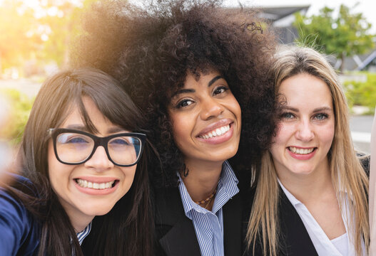 portrait of three mulitracial business women, selfie
