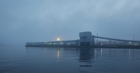 Cargo port terminal at night. Thick fog. Latvia, Baltic sea. Panoramic view. Service, repair,...