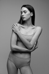 Portrait of beautiful young woman with perfect slim body posing in underwear. Black and white photography. Thin collarbones