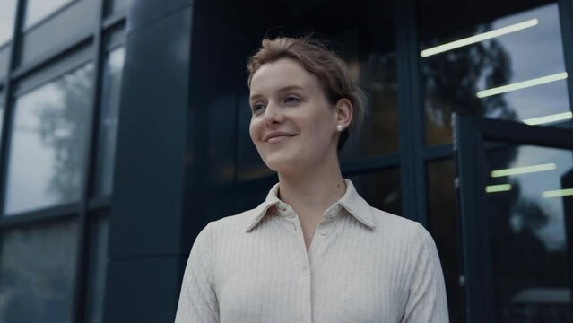 Portrait smiling teacher welcoming pupils at campus. Woman nodding to children.