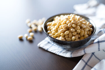 Soaked soy beans in black bowl on table