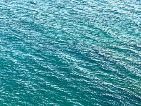 Sea water blue green background ripples surface.