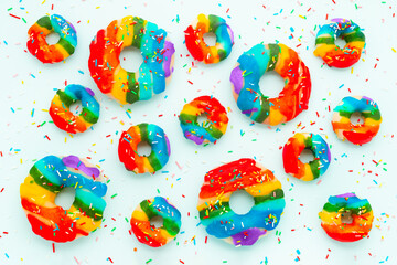 summer funny creative concept of donuts with sprinkles and icing rainbow colors over background