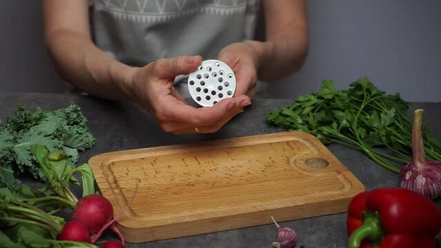 owner's woman in the kitchen demonstrates a gadget for cooking meat - tenzerider - makes many punctures with sharp needles in a piece of meat.