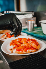 hand of chef baker making mini pizza at kitchen. The process of making pita pizza. cooking italian pizza
