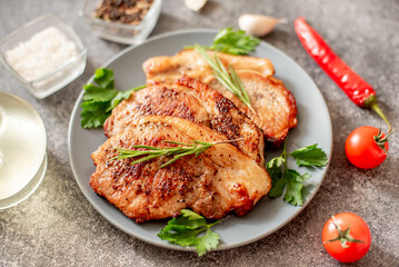 grilled pork steaks with spices on stone background