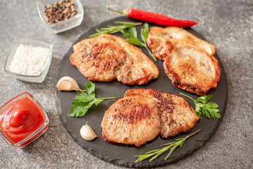 grilled pork steaks with spices on stone background