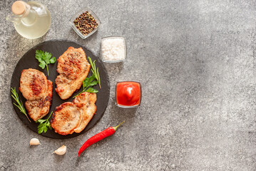 grilled pork steaks with spices on stone background with copy space for your text