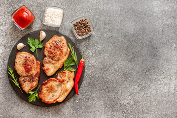 grilled pork steaks with spices on stone background with copy space for your text