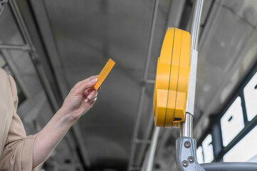 a woman pays with a plastic card for travel in public transport in a bus, tram or metro