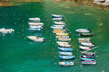 Elevated view of a group of small boats moored in the port of the ancient Vernazza village, Cinque...
