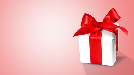 White gift box with red ribbon on gradient background.
