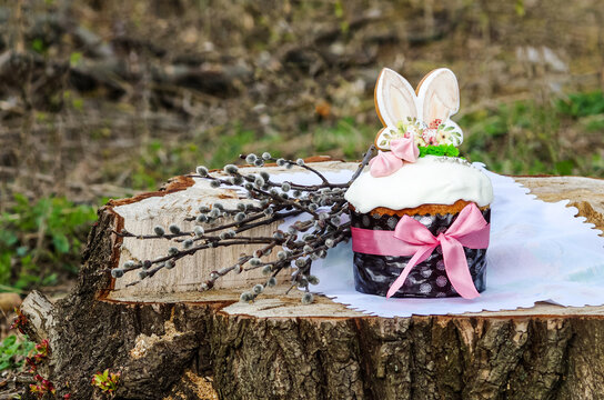 Fresh tasty Easter cake on a large log on a blurred background. Rabbit ears for cake. Easter easter bunny