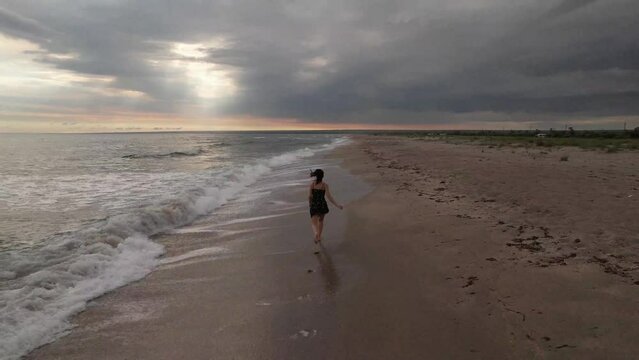 Girl running along the sandy beach