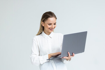 Portrait of a happy businesswoman working on laptop computer isolated over white background