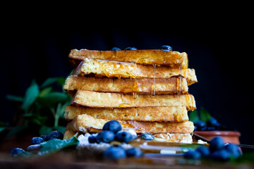 Waffles with fresh blueberries and honey on the rustic table. Freshly made Belgian waffles