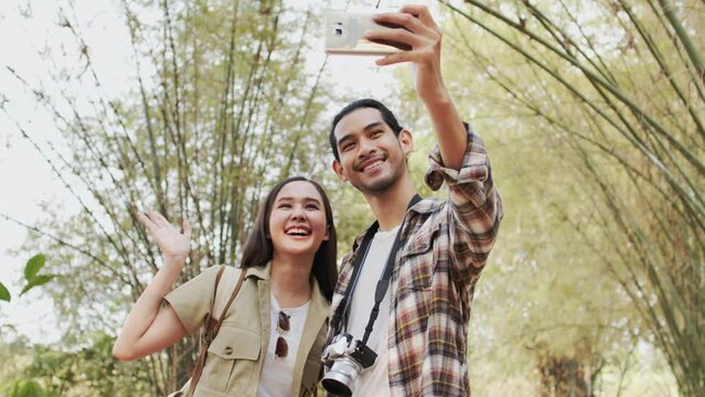 Two people having summer vacation use phone to take photo and selfie in forest. Slow motion, free time and outdoor relationship