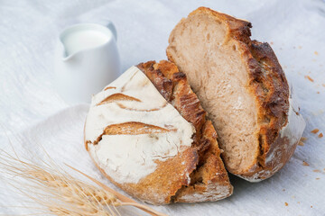 Fresh sourdough bread with a coffee mug on white fabric. Healthy eating breakfast.