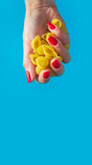 pasta Conchiglie in a female hand. high calorie food. calorie product. extra calories. Vertical image.