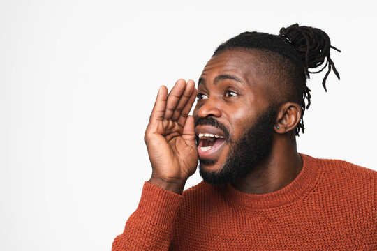 Young African-american Man With Dreadlocks In Red Sweater Talking Loud In Hand Like Loudspeaker Telling About Discount Sale Offer Isolated In White Background