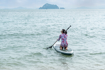 lonely woman  on Sup Bord surrounded in sea. Summer landscape. Active weekend vacations outdoor.